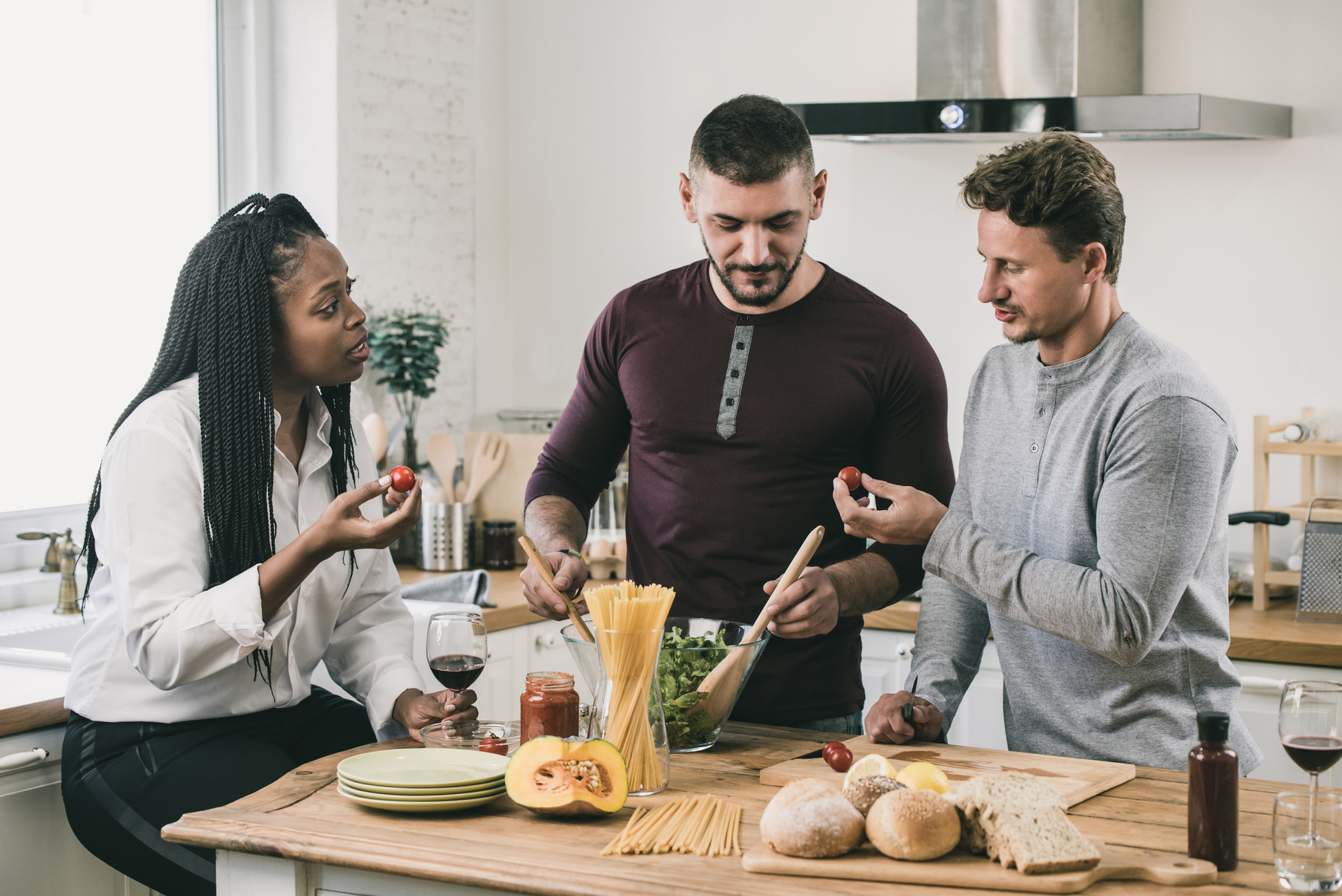 Mixed-raced people cooking in kitchen
